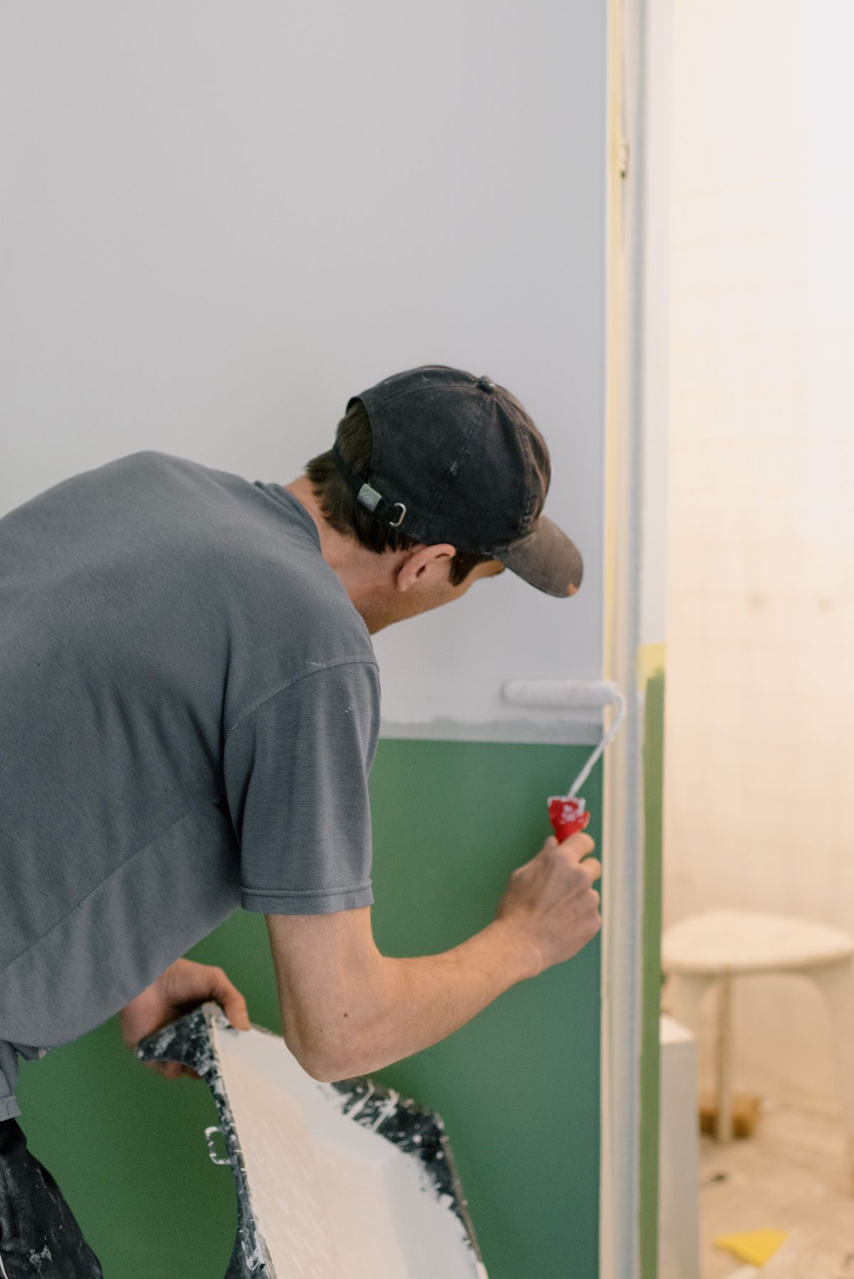 Peintre appliquant une peinture au rouleau dans un appartement en rénovation